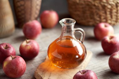 Bir sürahi elma sirkesi ve masada taze meyve.