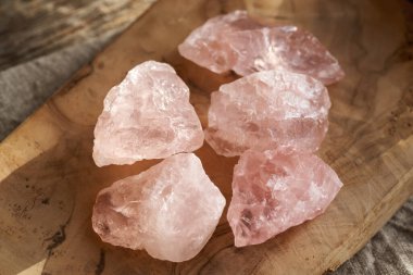 Tahta bir masada gül kuvars taşları