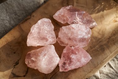 Ahşap bir masada pembe gül kuvars taşları