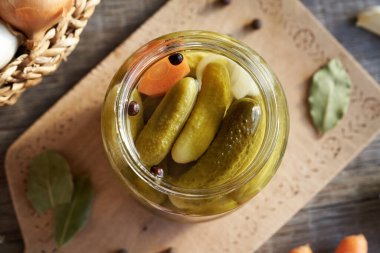 Masadaki cam kavanozda ev yapımı salatalık turşusu.