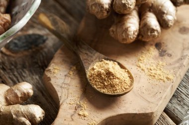 Bir masada zencefil tozu ve taze kök.