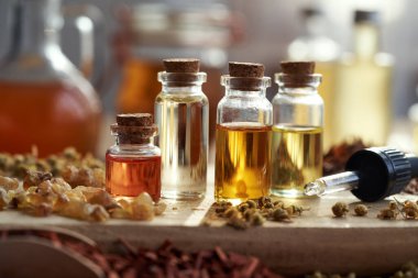 Birkaç şişe aromaterapi, tütsü reçinesi ve kurutulmuş bitkilerle gerekli yağlar.