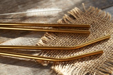 Ahşap bir masada fırçalı paslanmaz çelik pipetler.