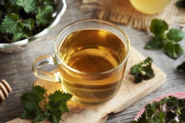 Baharın başında toplanmış taze ısırgan otlu bir fincan bitki çayı.