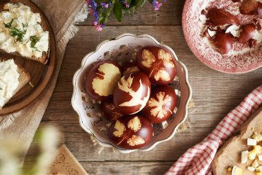 Kahverengi Paskalya yumurtaları soğan kabuklarıyla boyanmış, arta kalan haşlanmış yumurtalarla birlikte ekşi ekmek dilimleri, üst görünüm.