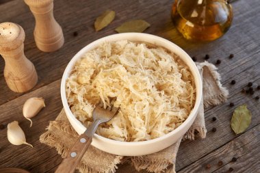 Ev yapımı mayalanmış lahana ya da ahşap bir masada beyaz bir kasede lahana turşusu.