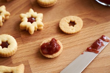 Geleneksel Linzer Noel kurabiyelerini çilek reçeli ya da marmelatla doldurmak.