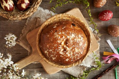 Mazanec denilen yuvarlak Çek tatlı paskalya pastası, soğan kabuklarıyla boyanmış yumurtalar ve ahşap bir masaya balmumuyla süslenmiş.