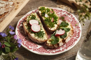 Üç dilim ekşi ekmeğe sarımsaklı hardal soğan ve goutweed ekleyin.