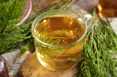 Taze at kuyruğu bitkisi ile bir bardak bitki çayı.