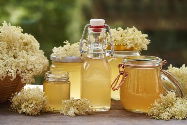 İlkbaharda hazırlanan ev yapımı elder çileği şurubu şişeleri ve kavanozları