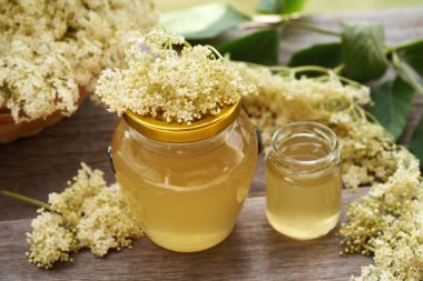 Baharda toplanan taze çiçeklerden elde edilen iki kavanoz ev yapımı mürver çiçeği şurubu.