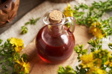 Yazın taze St. John otundan yapılmış bir kavanoz kırmızı yağ.