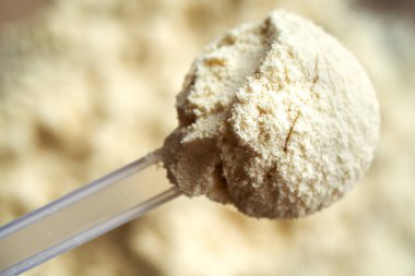 Bir ölçü kepçesinde beyaz protein tozunun en üst görünümü