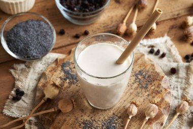 Cam bir fincanda ekolojik yeniden kullanılabilir bambu pipetli vegan haşhaş tohumu sütü.