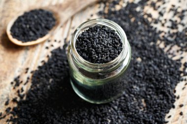 Siyah kimyon ya da cam kavanozdaki Nigella sativa tohumları. Sağlıklı besin desteği.