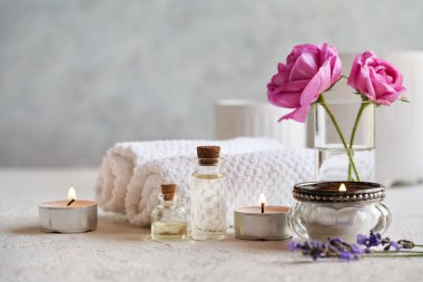 Lavanta ve gül desenli aromaterapi şişeleri ve mai çiçekleri ve kaplıca tedavisi aksesuarları beyaz arka planda fotokopi alanı ile birlikte