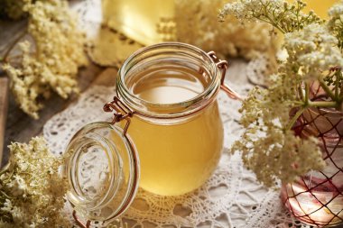 Mürver çiçeği şurubu masanın üzerinde cam bir kavanozda.