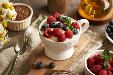 A cup of cottage cheese blended with flax seed oil with fresh blueberries and raspberries. Healthy breakfast. clipart