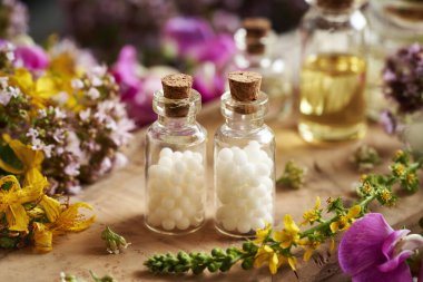 Masada renkli yaz çiçekleri olan homeopatik küreler.