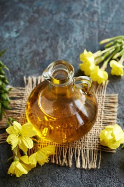 Bir sürahi gece çuha çiçeği yağı koyu arka planda taze çiçekler ve fotokopi alanı