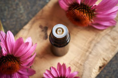 Bir şişe aromaterapi esaslı yağ ya da üzerinde mor ekinezi çiçekleri olan bir tentür.