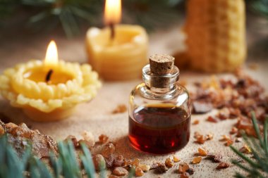 Arka planda balmumundan mumlar bulunan bir şişe reçine ve reçine. Aromaterapi ya da alternatif tıp.