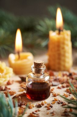 Arı mumundan yapılmış mum ve reçine içeren bir şişe reçine. Aromaterapi ya da alternatif tıp.