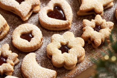 Ev yapımı Linzer Noel kurabiyeleri marmelatla doldurulmuş ve şekerle tozlanmış, yakın plan.