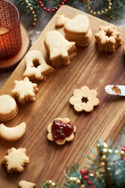 Geleneksel ev yapımı Linzer Noel kurabiyelerini kırmızı çilekli marmelatla doldurmak