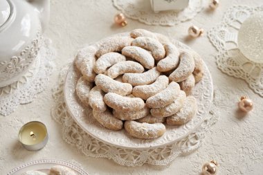 Kipferl denilen ev yapımı Noel kurabiyeleri ya da parlak arkaplanda beyaz bir tabakta vanilyalı hilal.