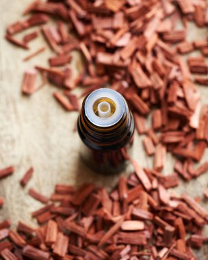 Masadaki kahverengi damlacıkta kırmızı sandal ağacı yağı.