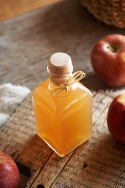 Ahşap bir masada elma sirkesi şişesi