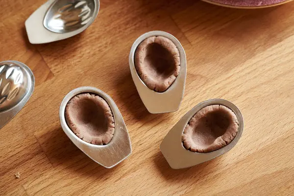 stock image Making homemade Christmas cookies in the form of nuts - pressing dough into tin moulds, close up