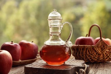 Bir bardak elma sirkesi ve açık havada taze meyve.