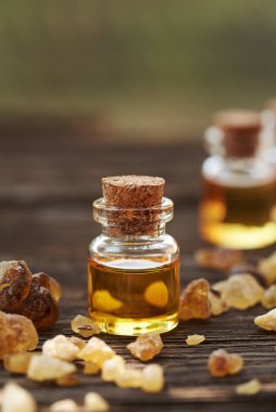 Bir şişe tütsü. Boswellia reçineli. Ahşap bir masada.