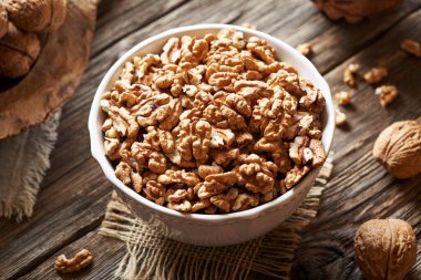 Tahta bir masada bir kase ceviz. Sağlıklı yağların kaynağı.