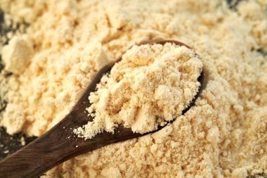 Tahta kaşıkta beyaz protein tozu, yakın çekim.