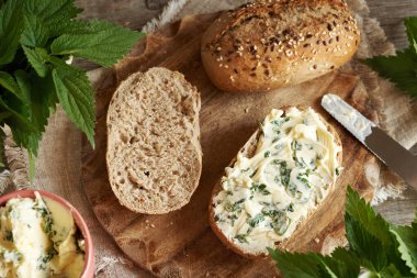 Isırgan otu yağı. Yenilebilir yabani bitkilerden yapılmış ev yapımı ekmek. Bir dilim ekşi ekmek.