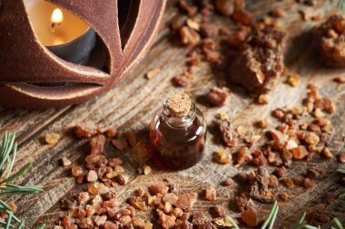 Şeffaf bir yağ şişesi, içinde reçine ve Noel 'de mum var.