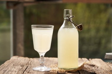 Cam bir şişede taze süt ve açık bir masada bardak. Protein takviyesi.