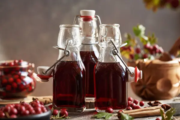 stock image Three bottles of medicinal wine prepared from fresh hawthorn berries ans spices in autumn