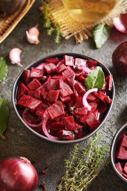 Siyah bir kasede soğan, sarımsak ve baharatla mayalanmış kırmızı pancar.