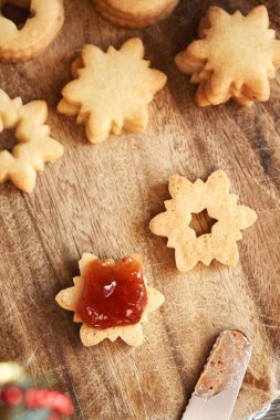 Yıldız şeklinde Linzer Noel kurabiyesi, kırmızı çilek reçeli, üst manzara.