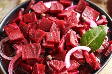 Koyu bir kasede soğan ve baharatla mayalanmış kırmızı pancar kvass, yakın çekim.