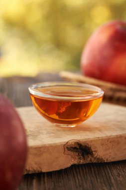 Bir kase elma sirkesi ve masada taze meyve.