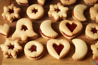 Kırmızı çilek marmelatıyla dolu ev yapımı Linzer Noel kurabiyeleri.