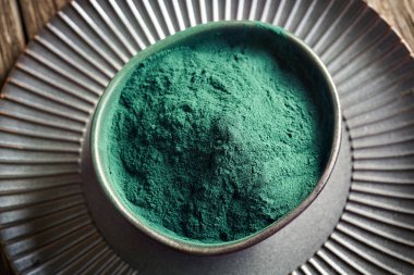 Masadaki siyah kasede yeşil spirulina tozu