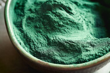 Bir kasede yeşil spirulina yosunları tozu, yakın çekim.