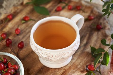 Taze böğürtlenli beyaz bir fincan kalça çayı.